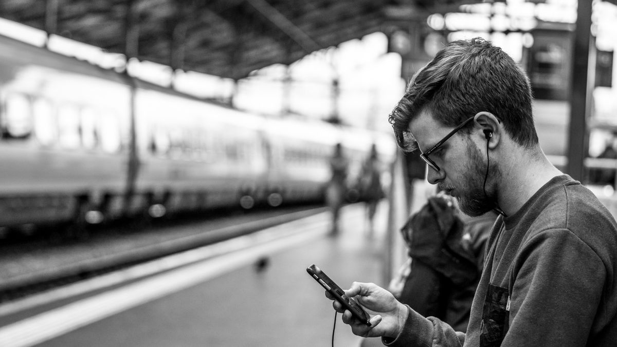 person studying on smartphone during train commute