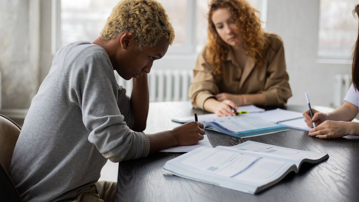 cook studying textbook at kitchen table
