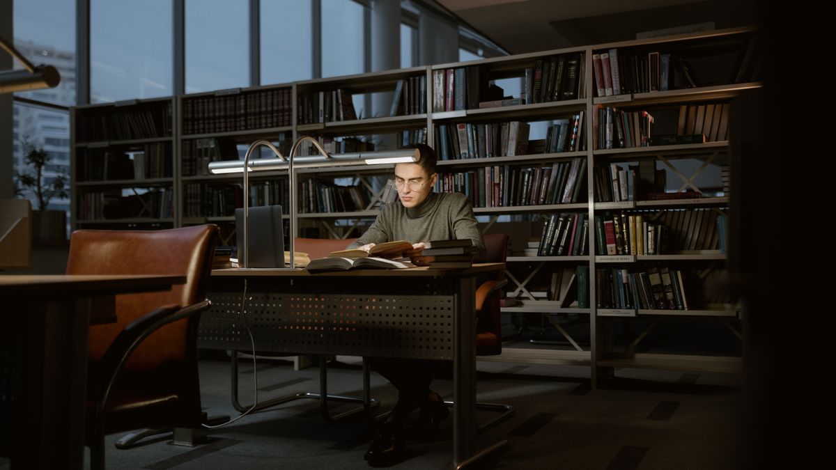 engineer studying electrical textbook at desk night