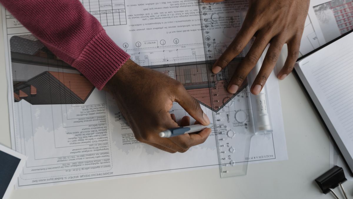 architect reviewing blueprints at desk