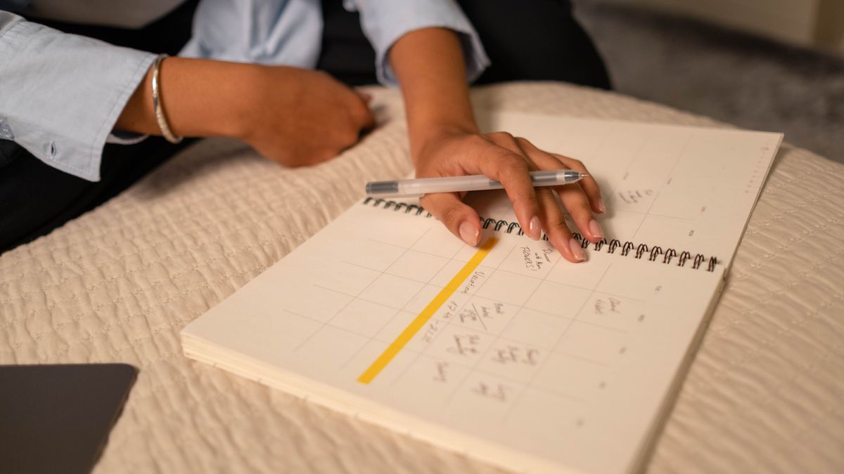 person studying textbook at desk with calendar