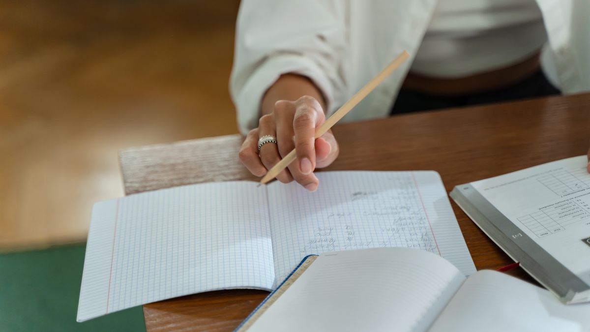 adult studying kanji workbook at desk