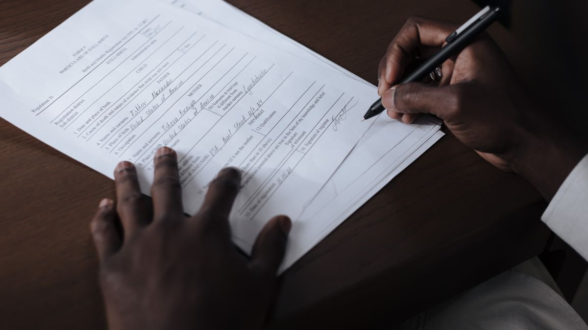 person filling application form at desk