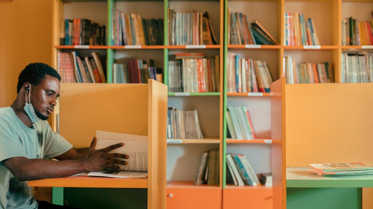 person studying textbook at desk evening