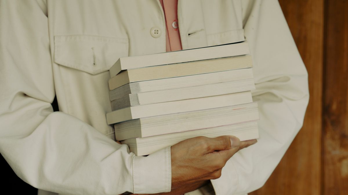 person comparing textbooks in bookstore