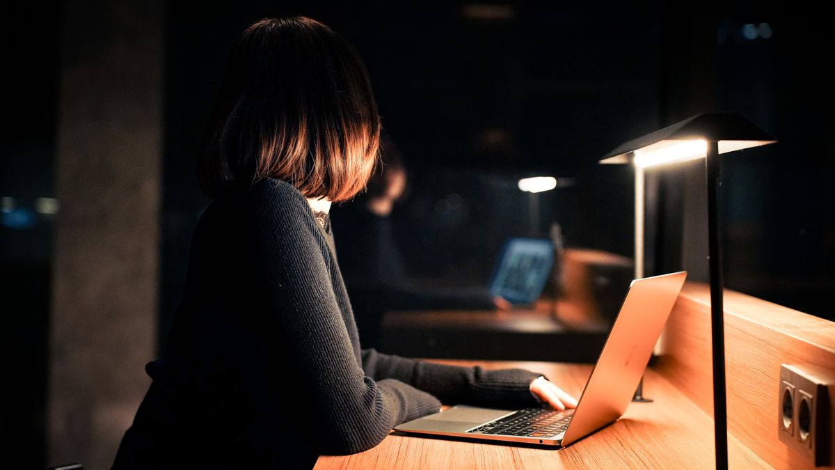 person studying laptop desk night