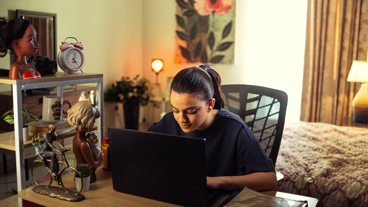 person working on laptop at home desk
