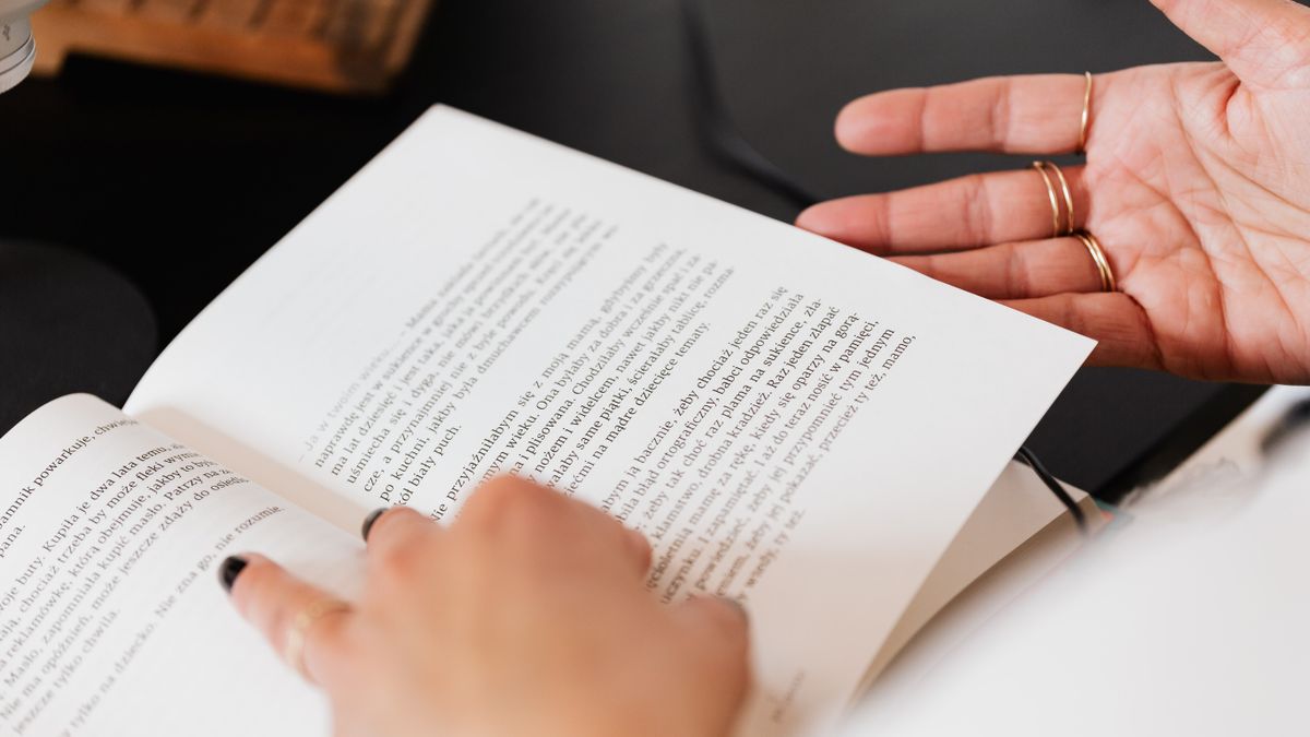 person reading textbook at desk