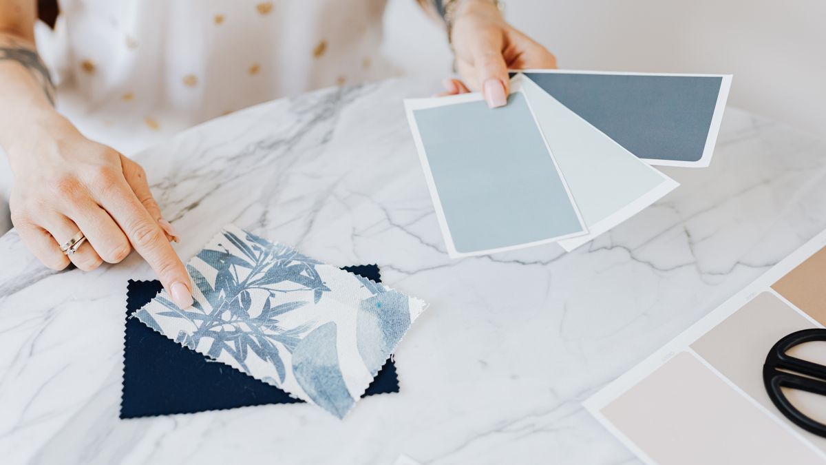 woman studying color swatches at desk