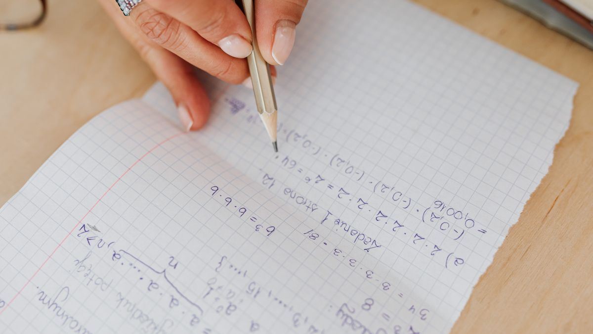 person solving practice exam questions at desk