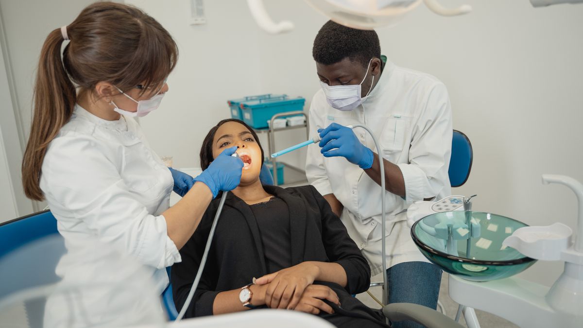 dentist with assistant treating patient