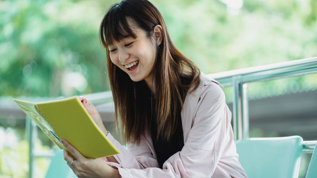 adult studying kanji workbook at desk