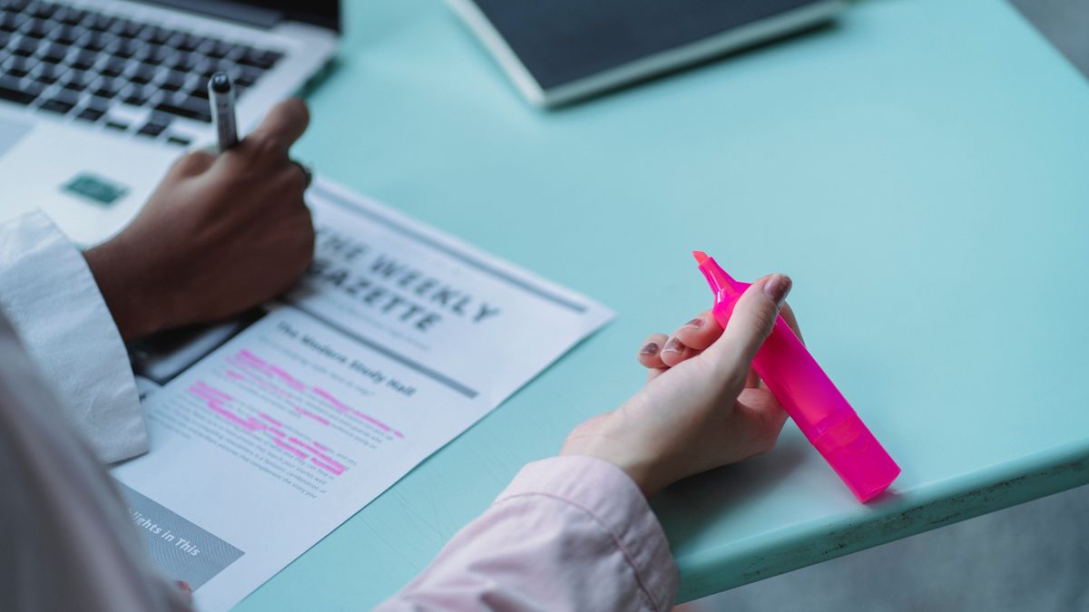 person studying with highlighter notebook