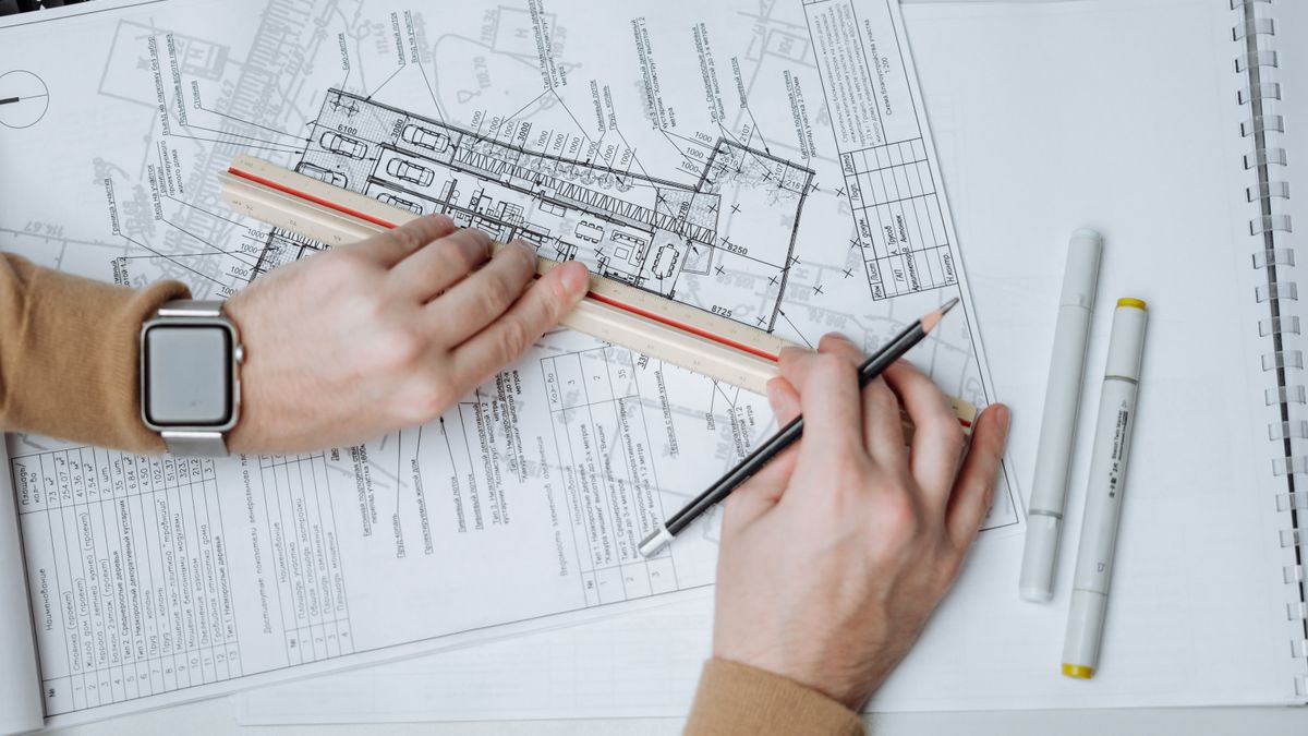 clock on desk with architectural blueprints