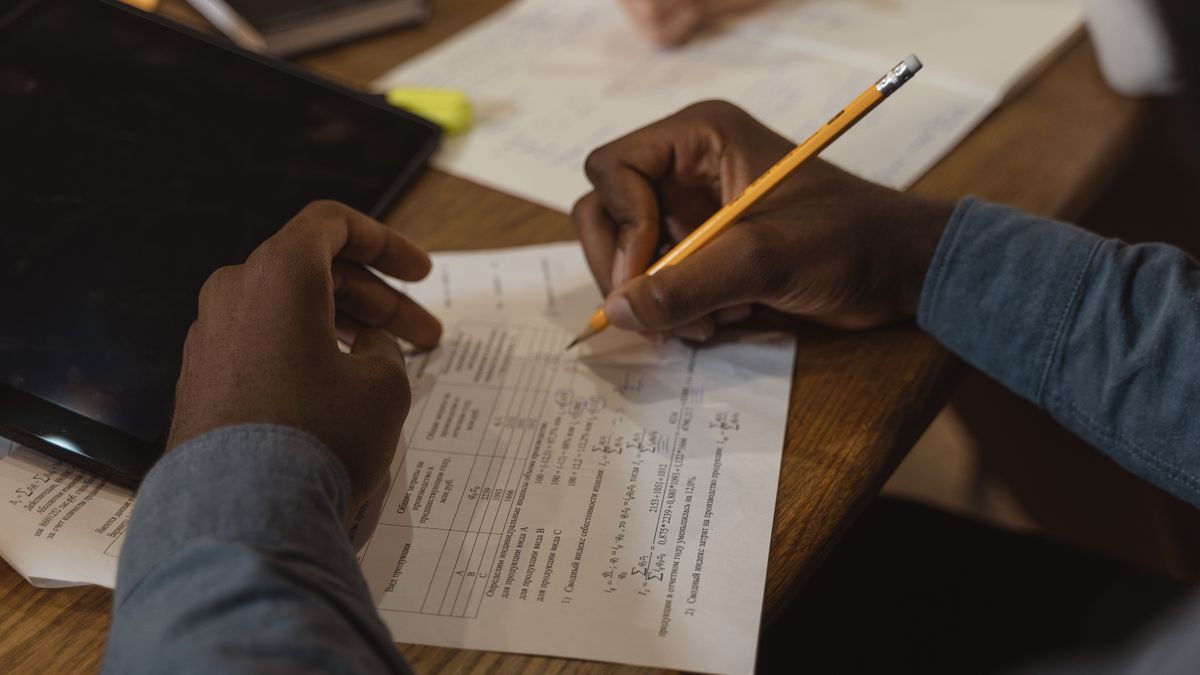person solving practice exam questions at desk