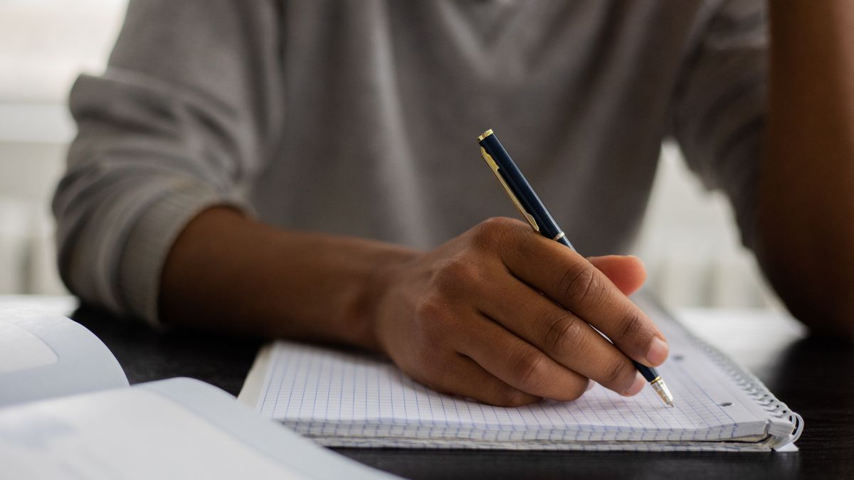 student writing notes at desk