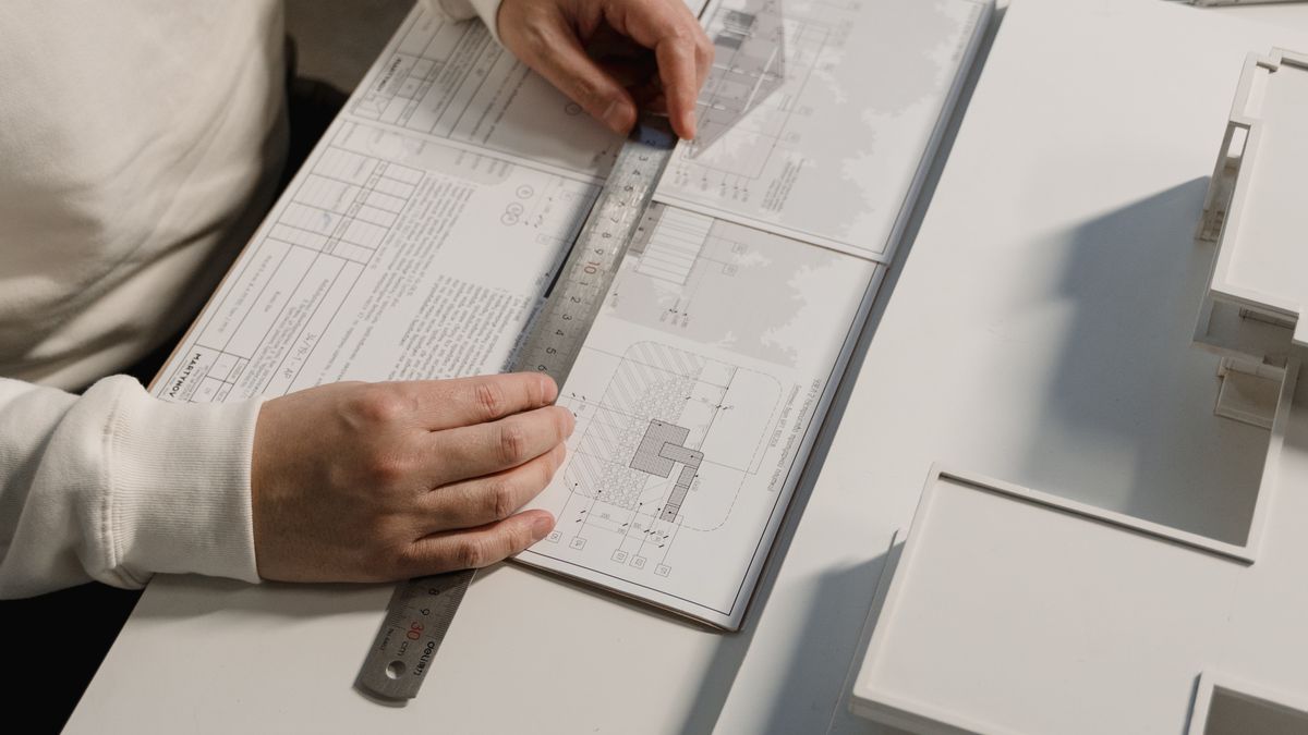 architect drawing floor plan on drafting board