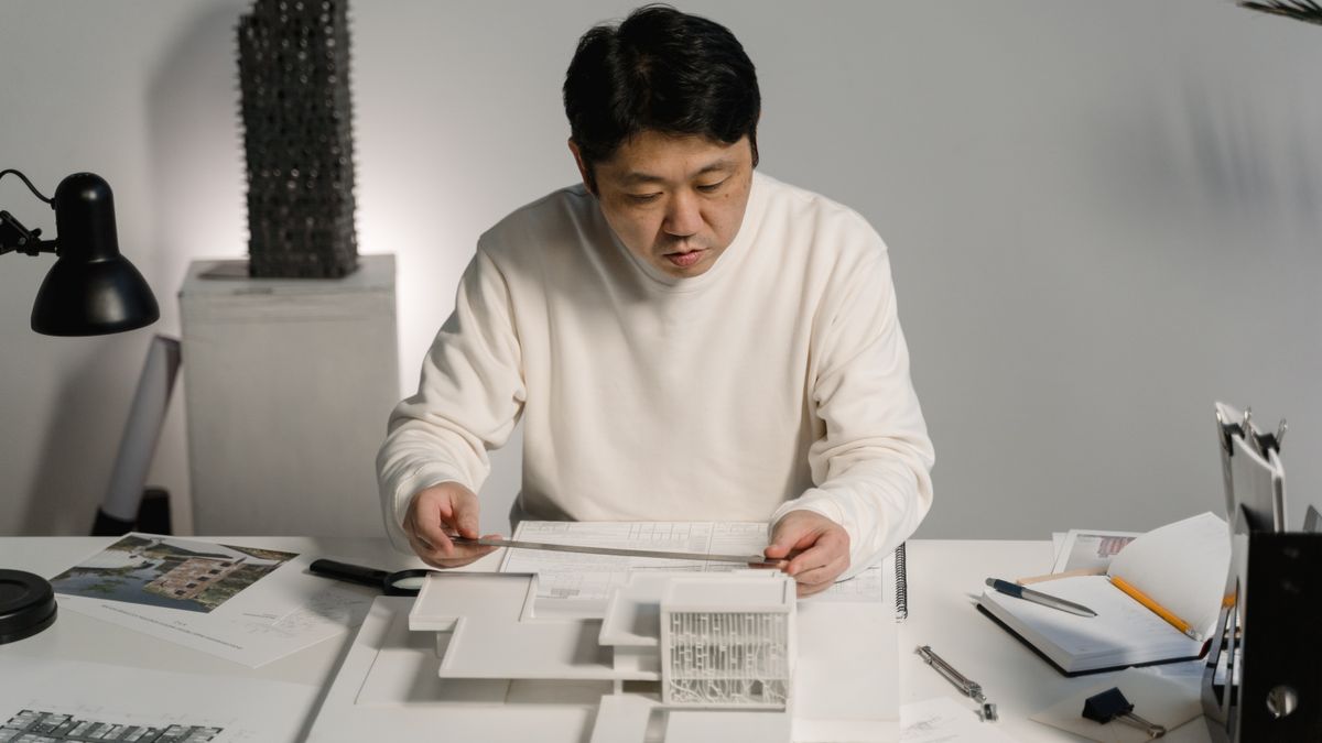 architect studying blueprints at desk