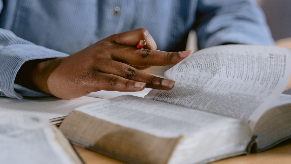 person studying textbook at desk