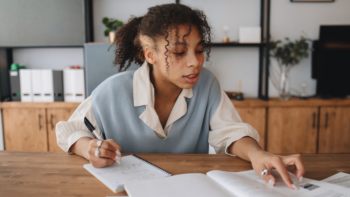 woman writing study plan notebook