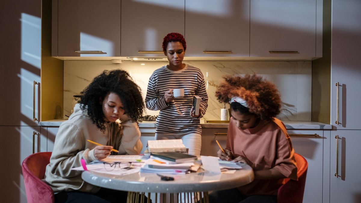 woman studying textbook at kitchen table