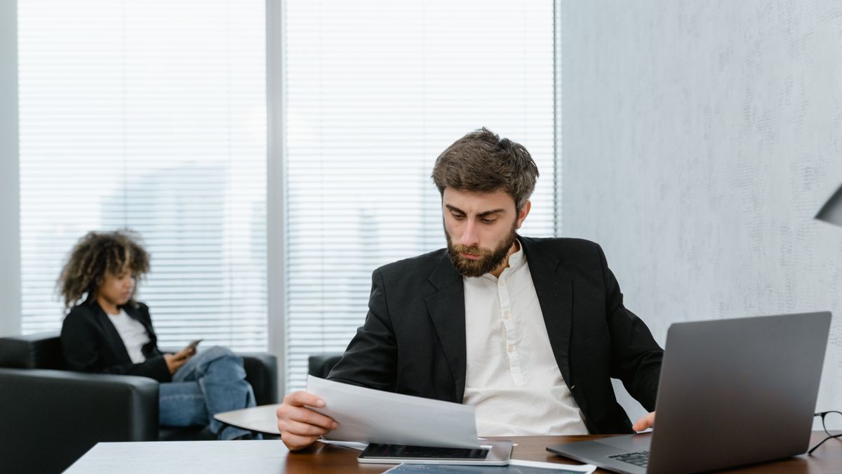 office worker reviewing documents on laptop