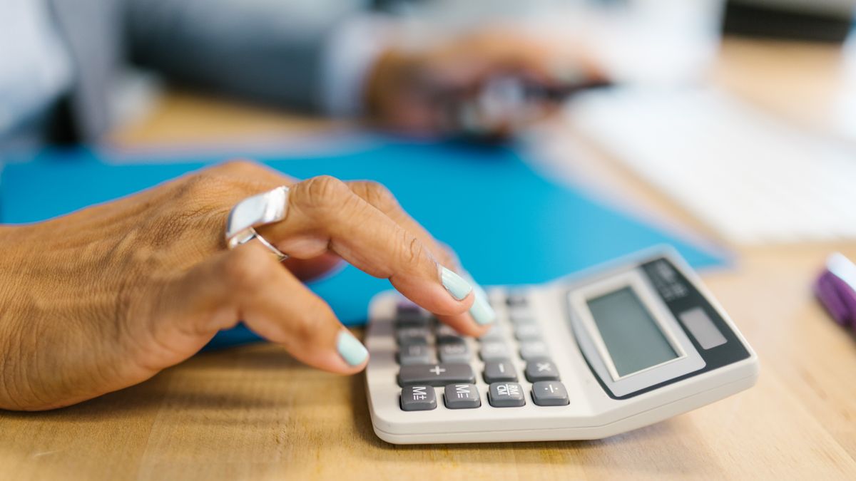 person studying bookkeeping with calculator at desk