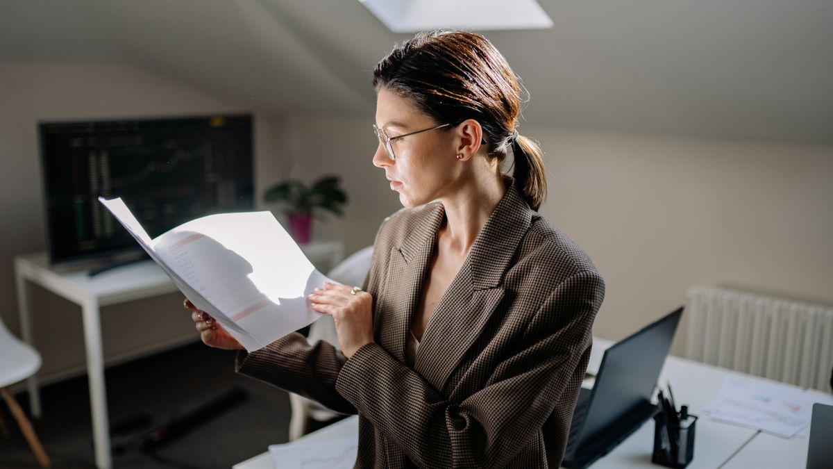 woman studying finance textbook at desk