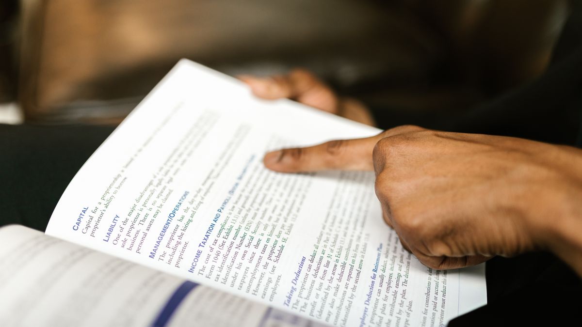 person studying finance textbook with calculator