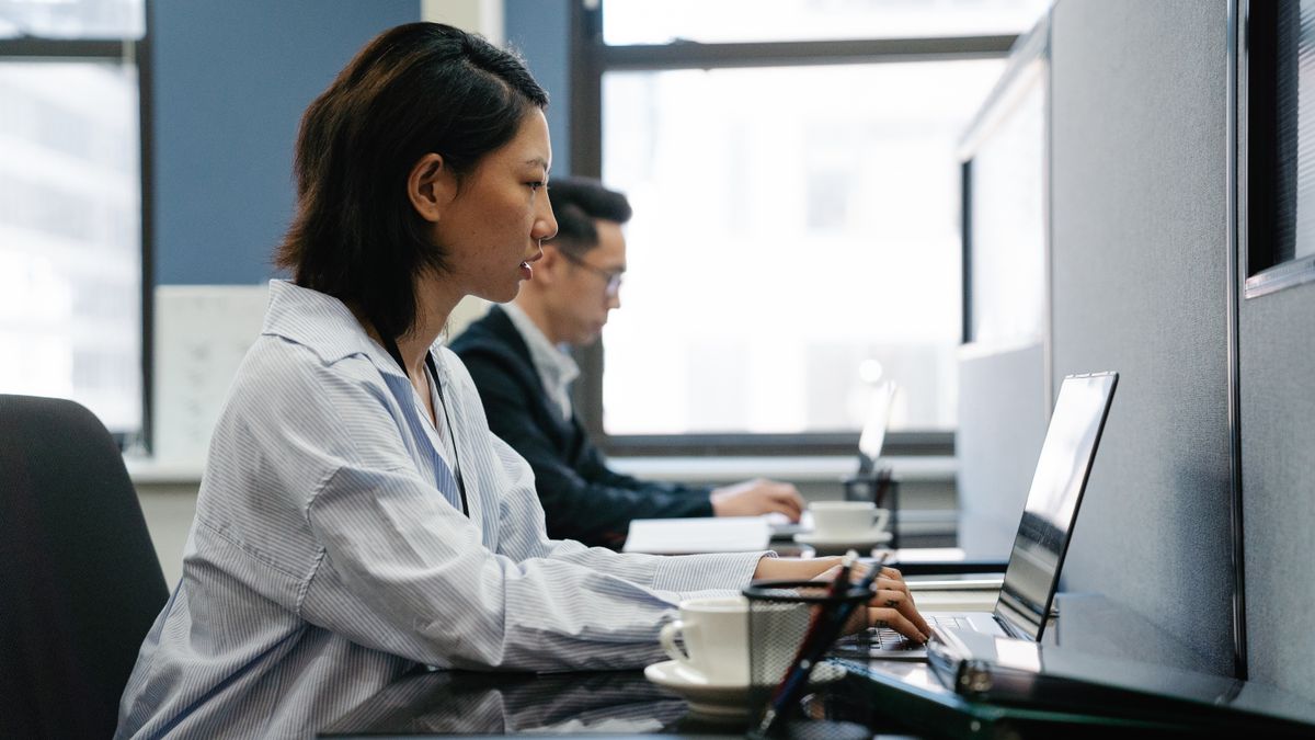 office worker comparing two exam guidebooks at desk
