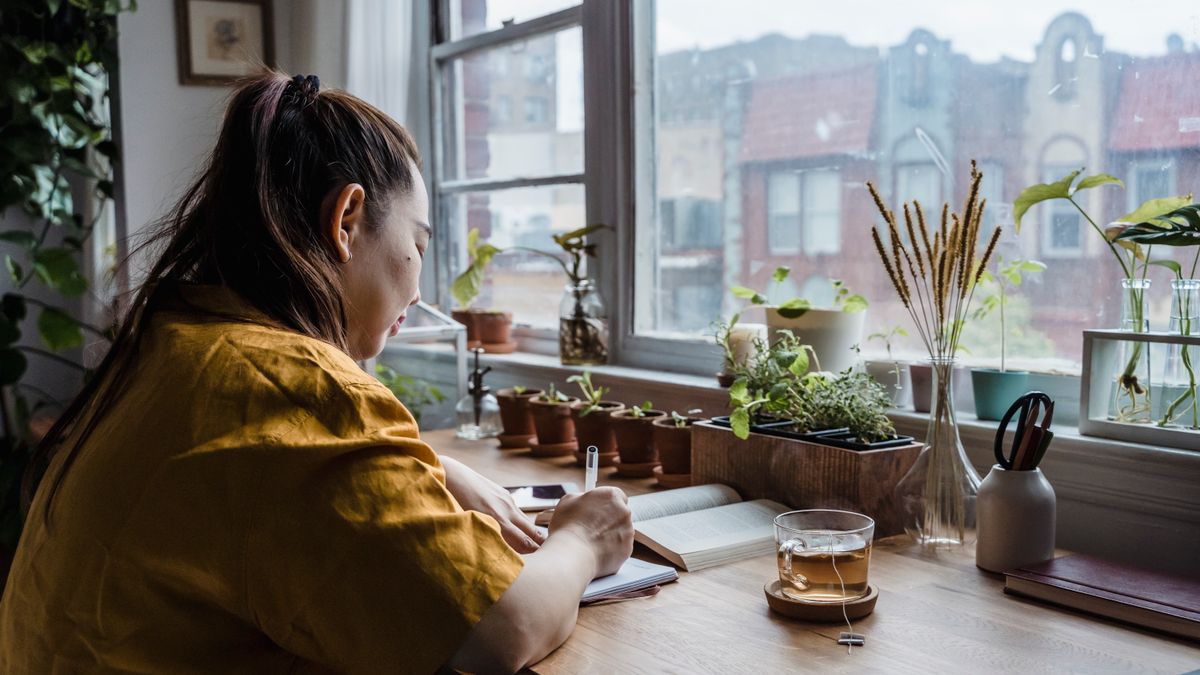 woman studying textbook at home desk