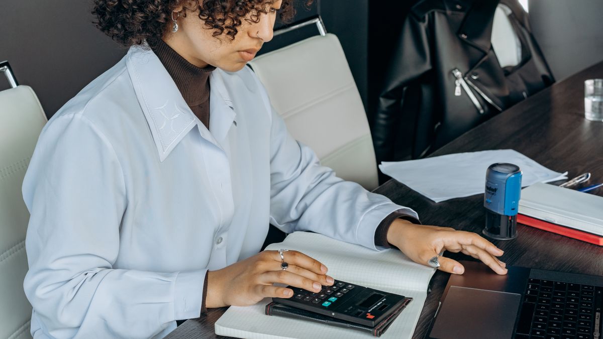 person studying bookkeeping with calculator at desk