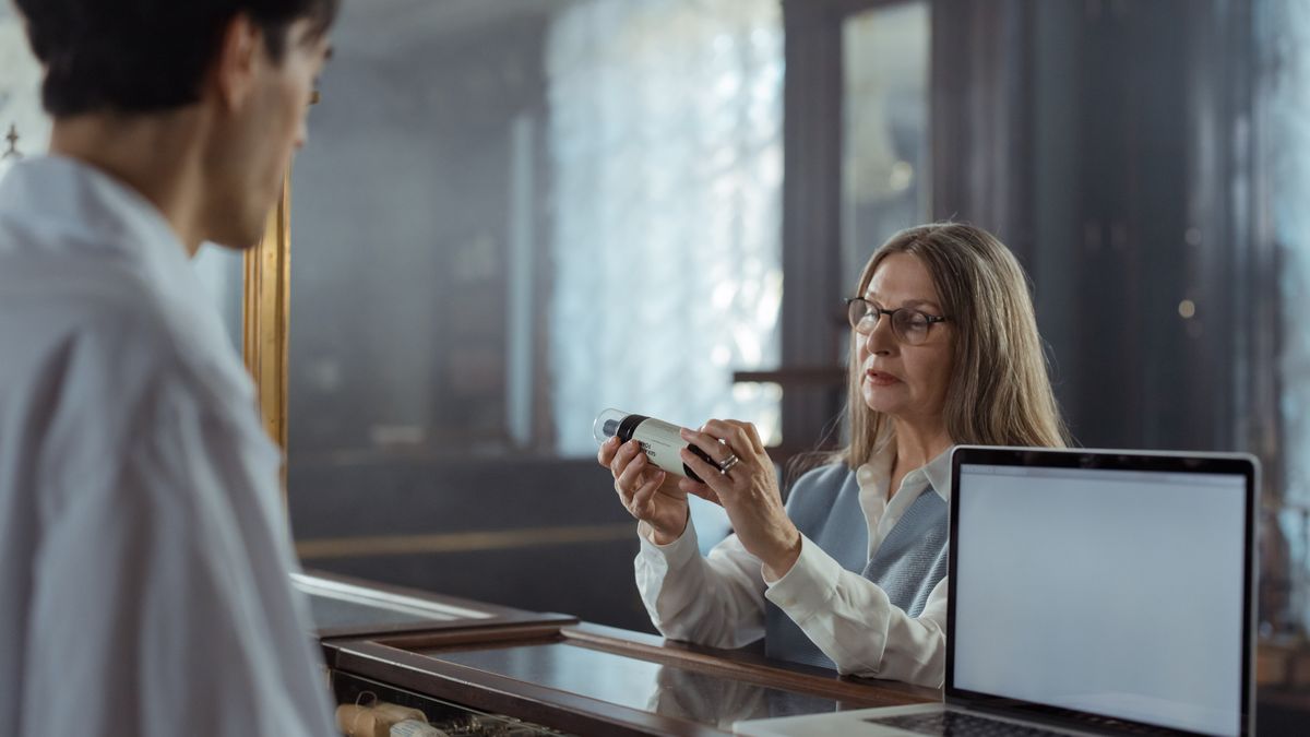 pharmacist explaining medicine to customer at drugstore counter