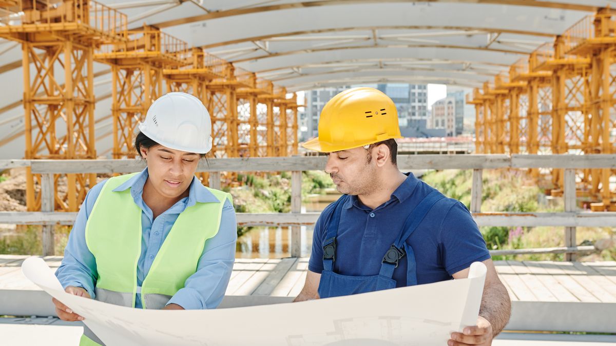 construction manager checking blueprints at building site