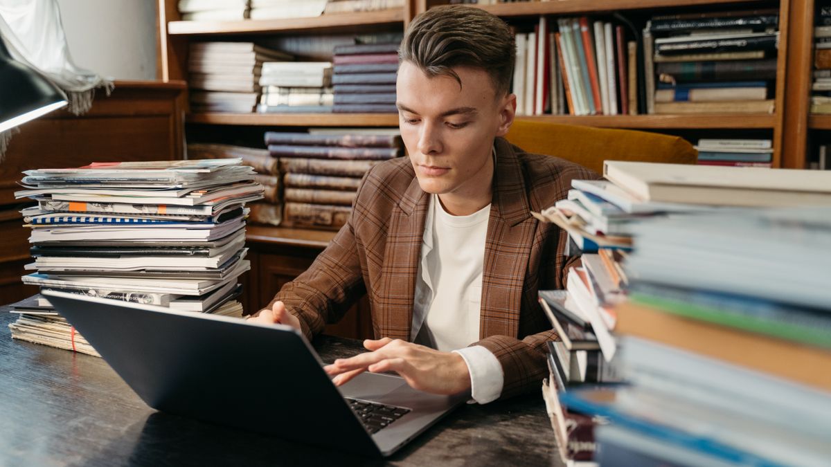 person studying law textbook with laptop
